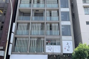A multi-story building with a modern architectural design, featuring a series of balconies and large windows. - Entire apartment in Higashi Shinjuku (Tokyo)