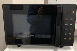 A black microwave with a digital display and control panel. - Entire apartment in Higashi Shinjuku (Tokyo)
