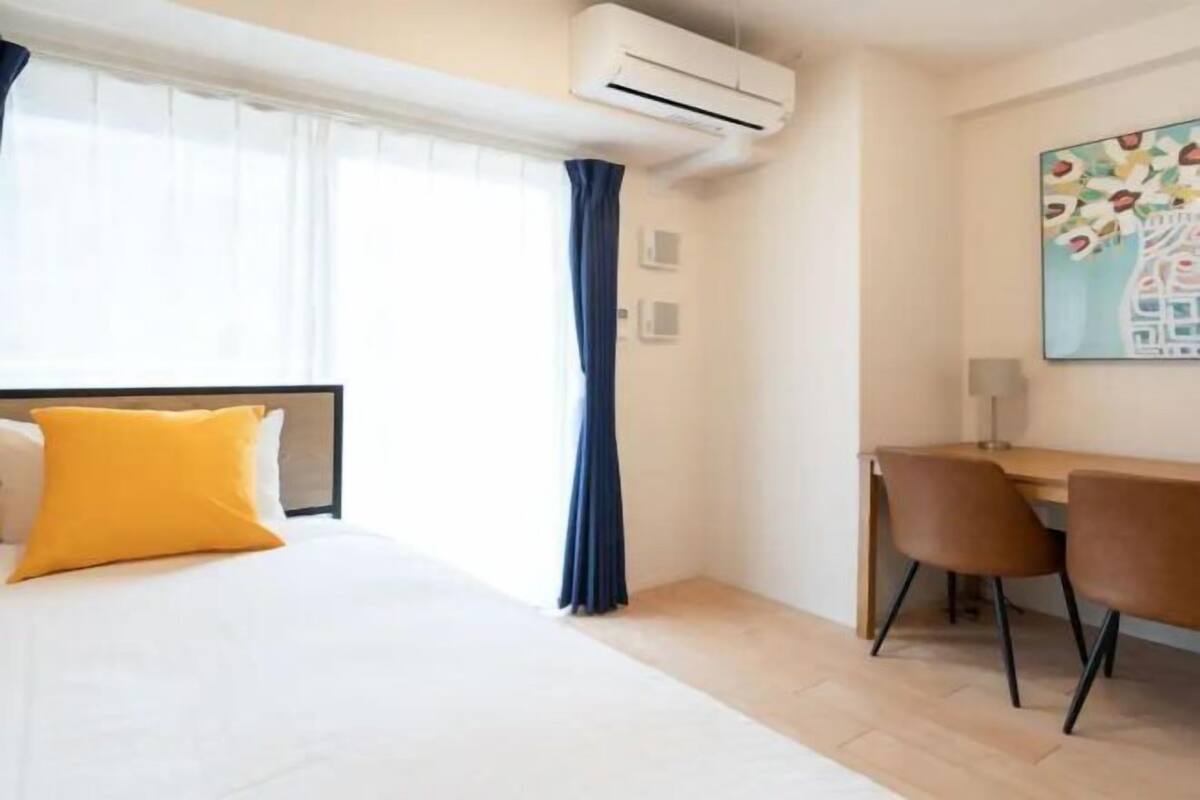 A hotel room with a bed, a desk, and a chair.