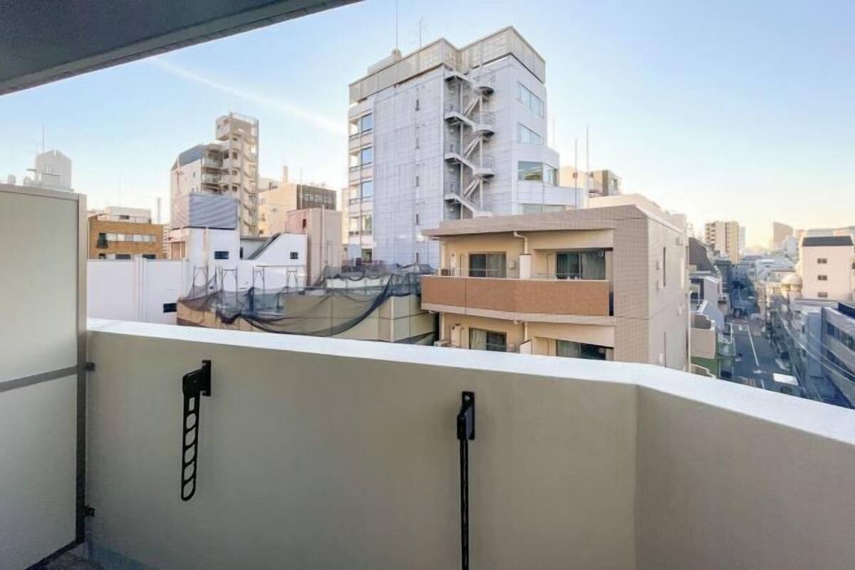 A balcony with a view of a cityscape, including buildings of various heights and architectural styles.