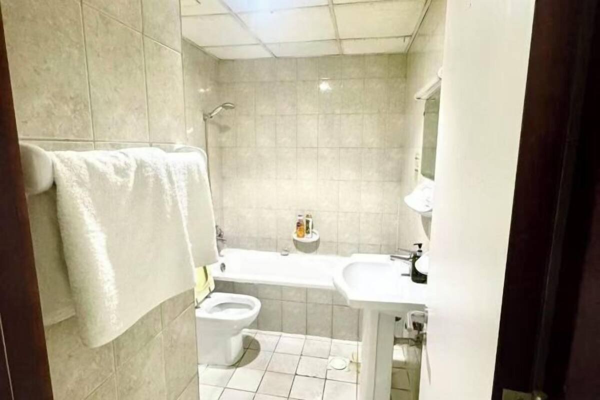 Une salle de bain avec des toilettes, un lavabo et une douche.