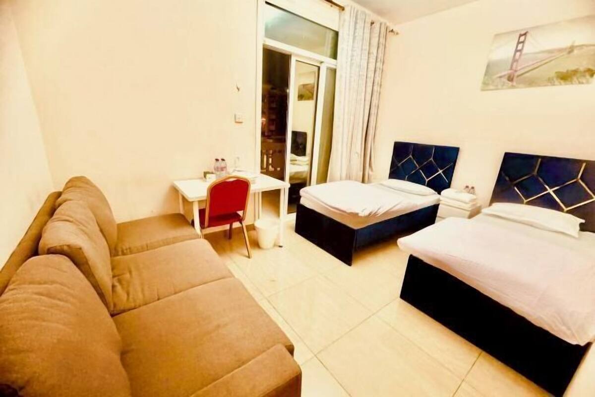 Une chambre d’hôtel avec un canapé, un lit, un bureau et une chaise.