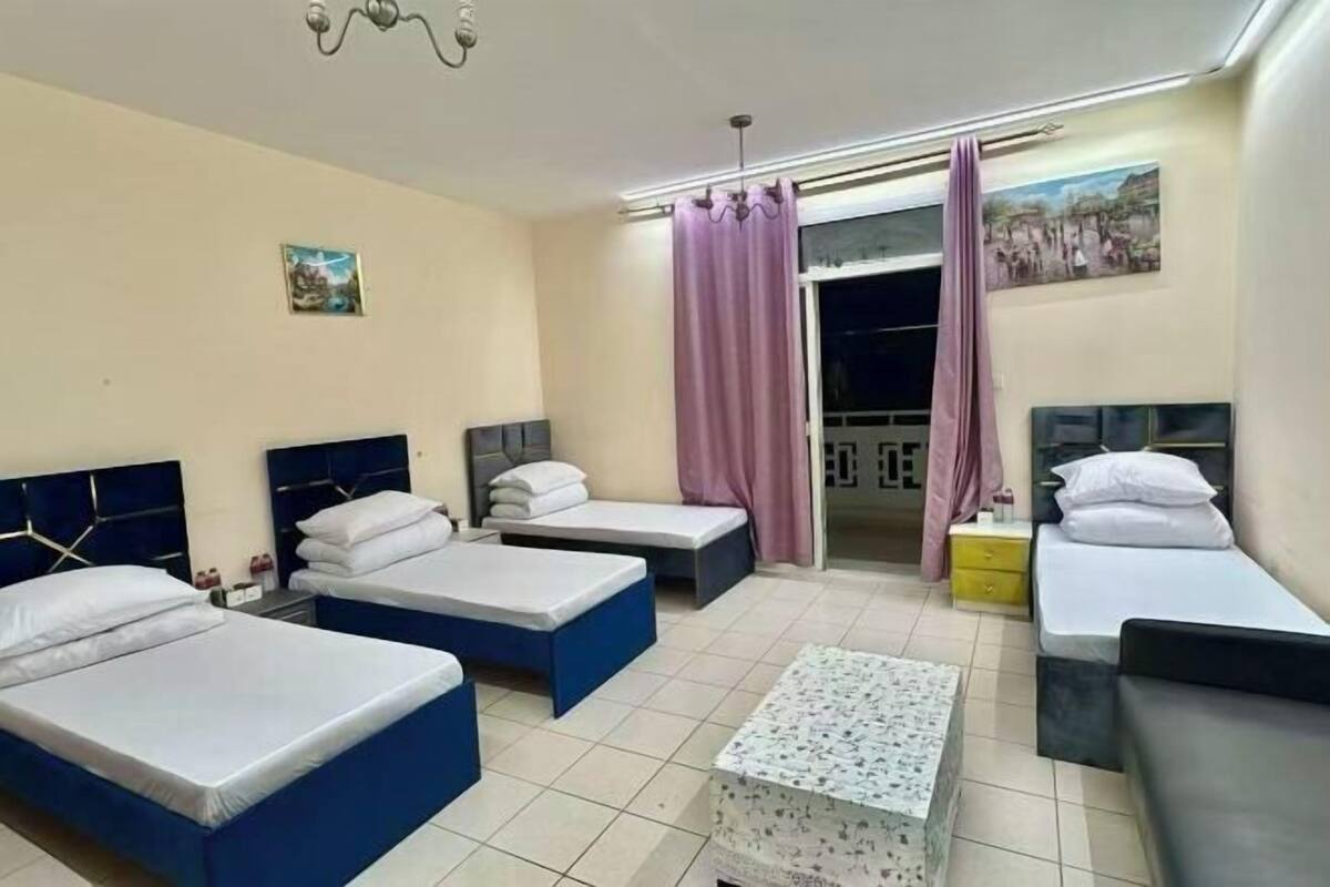 Une chambre d’hôtel avec deux lits simples, une petite table et un canapé.