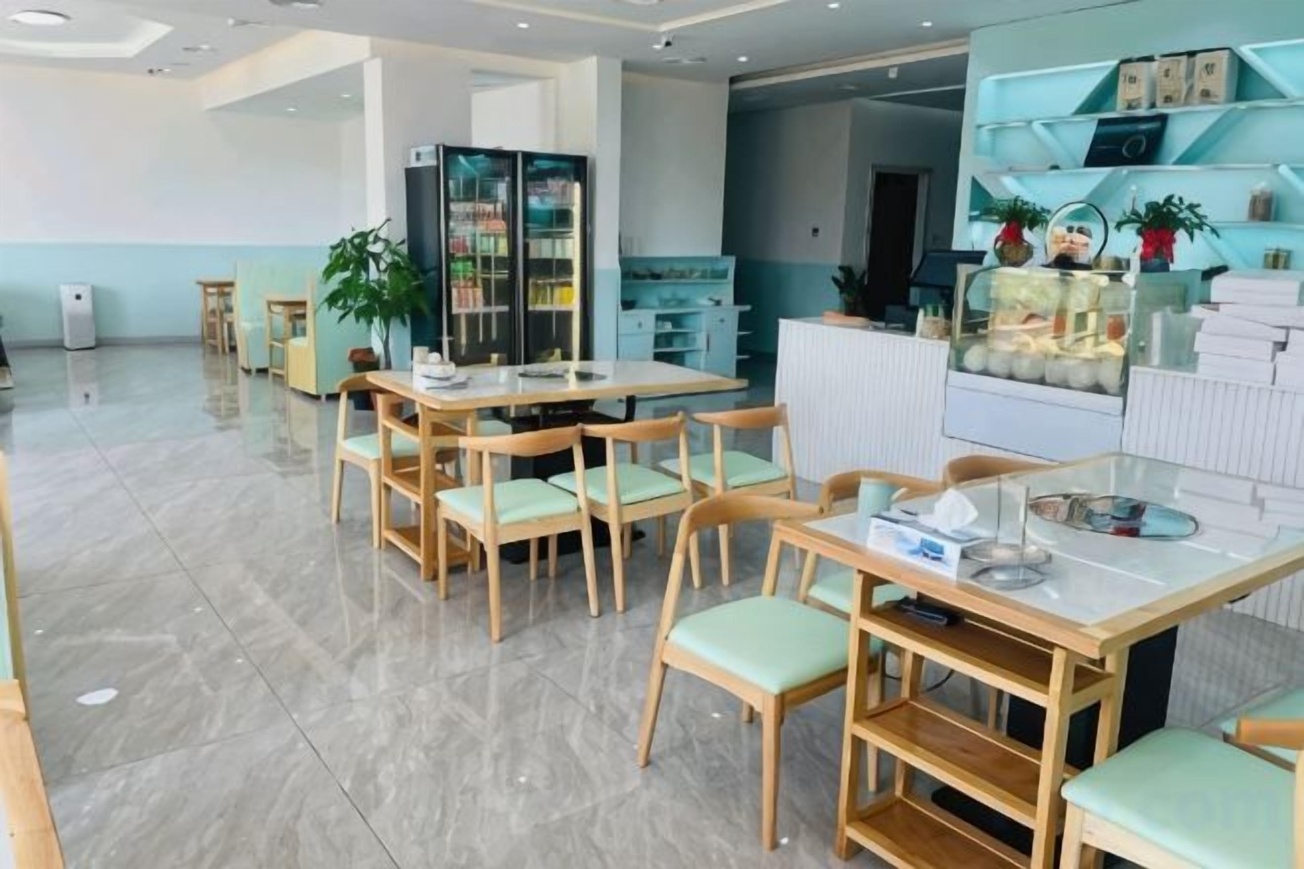 A modern hotel lobby with a reception desk, seating area, and a display case.