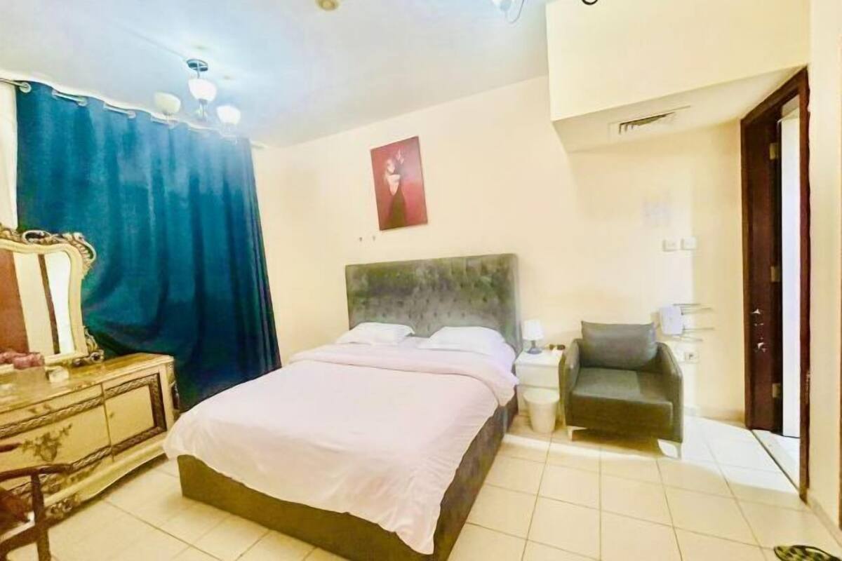 Une chambre à coucher comprenant un lit, une table de chevet, une chaise et une commode.