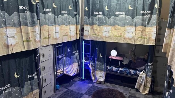 A room with a bunk bed, a small desk, and a chair. There are curtains with a space theme. - Orange Home Vacation (Dubai)