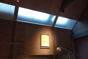 A room with skylights, a framed picture, and a lamp. - At Hotel ORTO (Fukuoka)
