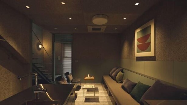 A modern interior with a sofa, a small table, and a staircase. - At Hotel ORTO (Fukuoka)