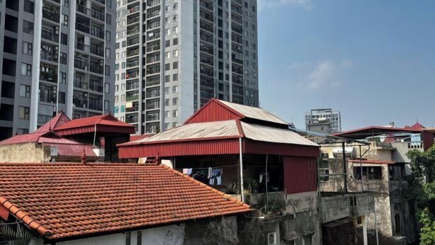 A residential area with a mix of modern high-rise buildings and older, smaller houses with red-tiled roofs. - Hoe Stay - Where to stay (Hanoi)