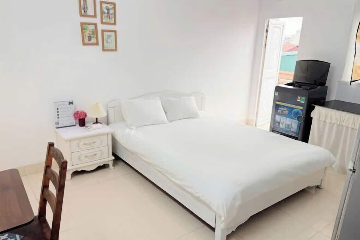 Une chambre à coucher comprenant un lit, une table de chevet, une chaise, un bureau et un téléviseur.