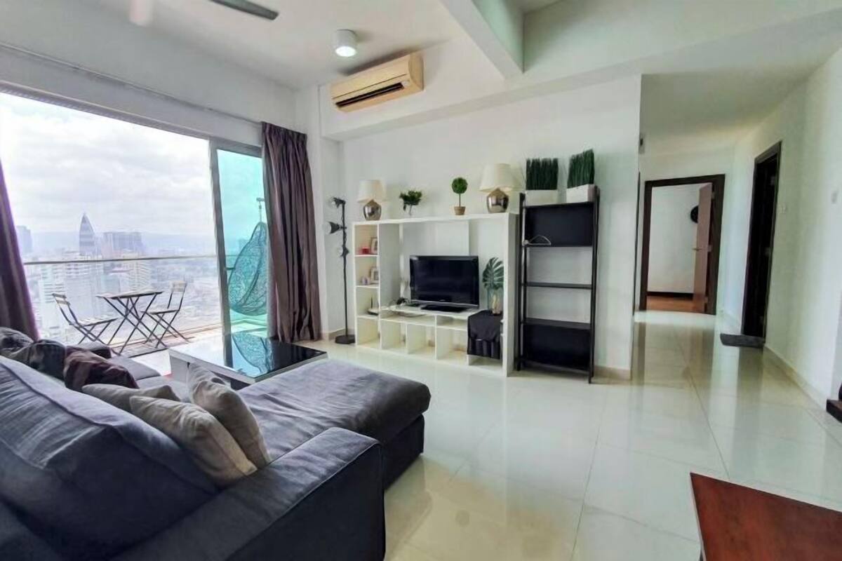 Una sala de estar moderna con sofá, televisor y estanterías.