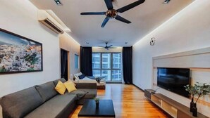 Una sala de estar moderna con sofá, mesa de centro, televisor y ventiladores de techo.