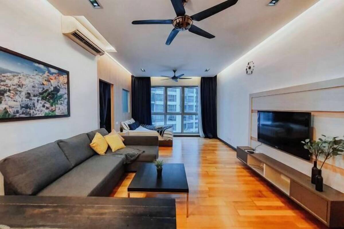 Una sala de estar moderna con sofá, mesa de centro, televisor y ventiladores de techo.