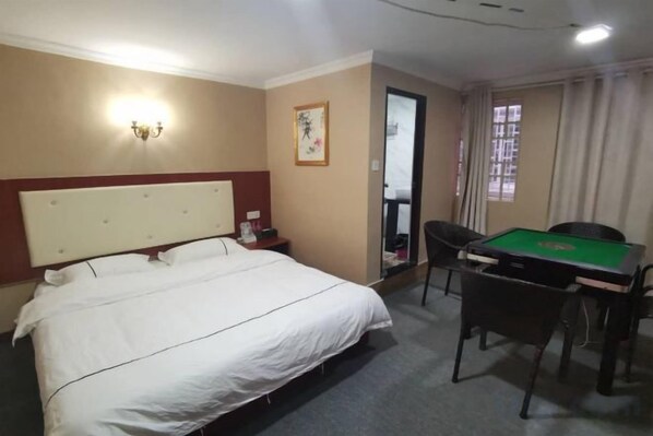 Una habitación de hotel con una cama, un escritorio con una mesa verde y una silla.