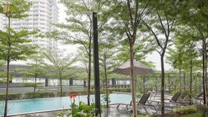 Un espace piscine avec des chaises longues, une pergola et une vue sur un bâtiment en arrière-plan.