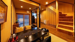 A traditional Japanese interior with a tatami mat room, a wooden staircase, and a sliding door. - AOU･SEITOKKU (Osaka)