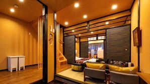 A hotel room with a bed, a sofa, a small table, and a mirror. - AOU･SEITOKKU (Osaka)
