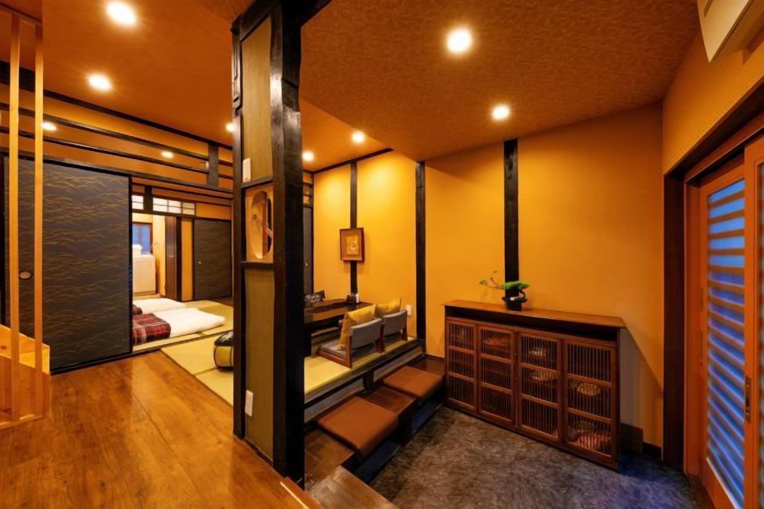 A traditional Japanese interior with tatami flooring, a low wooden bench, and a sliding door.