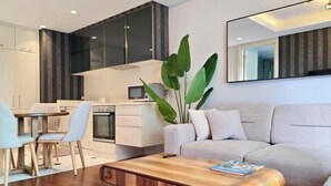 Una sala de estar moderna con sofá, mesa de centro y comedor.