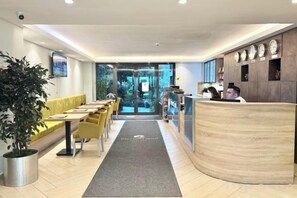 A hotel reception area with a reception desk, seating area, and a potted plant. - Ofton Elysium Soul Residence (Istanbul)