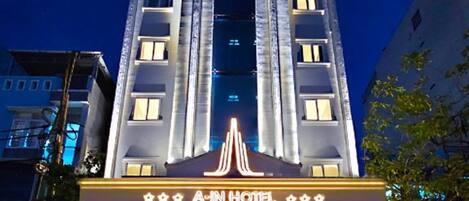 Um hotel com design arquitetônico clássico, apresentando uma entrada central com letreiro de toldo.
