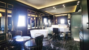 A modern bathroom with a bathtub, vanity, and seating area. - A In Hotel Atistar (Ho Chi Minh City)