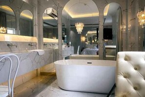 A modern bathroom with a freestanding bathtub, marble walls, and a large mirror. - A In Hotel Atistar (Ho Chi Minh City)