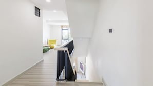 A modern interior with a staircase leading to a living area. - Bangkok Four-Bedroom Single Family Villa [near Sangtai Shopping Center + Royal Park] (Bangkok)