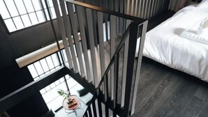Una habitación moderna con cama, escritorio y vistas al exterior.