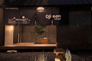 Un edificio con un escenario, pancartas, una plataforma de madera y una estructura de piedra al frente.