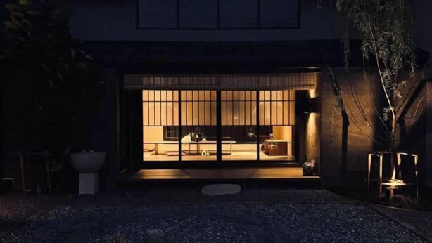 Un interior japonés tradicional con suelo de tatami, una mesa baja y una puerta corredera.