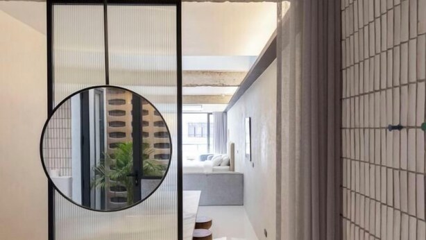 Un interior moderno con un espejo redondo, una puerta corredera y un diseño minimalista.
