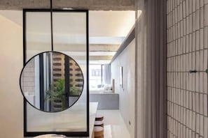 A modern interior with a round mirror, a sliding door, and a minimalist design.
