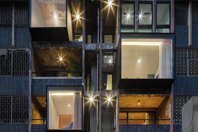 Un edificio de varios pisos con balcones, ventanas y un espacio interior visible.