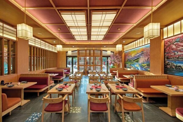 Ein traditionelles japanisches Restaurant mit Holzmöbeln, Tatami-Matten und einem zentralen Gang.