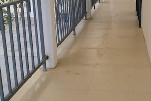 A corridor with a tiled floor and metal railings. - Happy Hotel (Vientiane)
