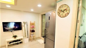 A modern kitchen with a stainless steel refrigerator, a wall-mounted clock, and a flat-screen TV. - Seoul Dajeong House/Hongdae Entrance Sta.Exit7. Party room. Lovely Big House (Seoul)