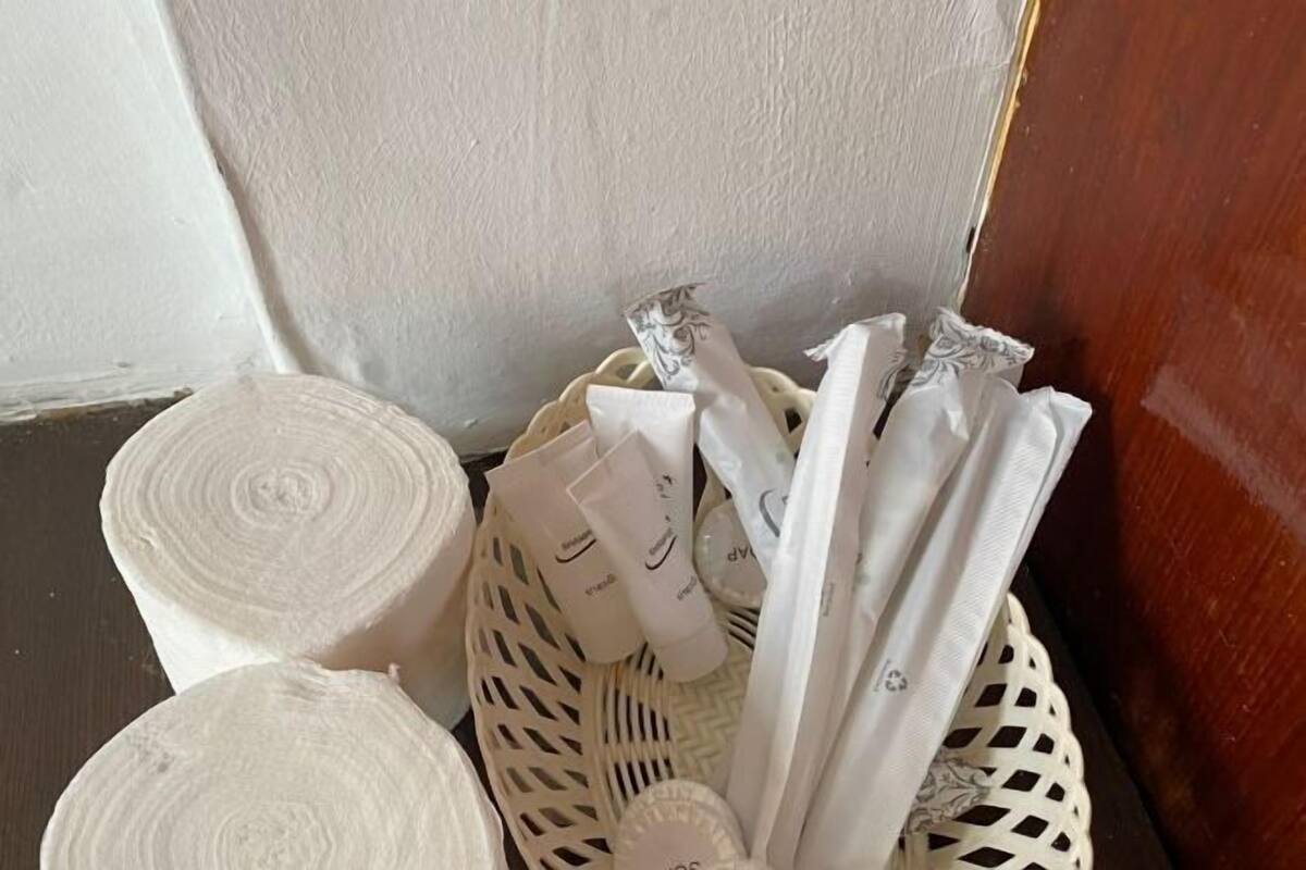 A wicker basket containing rolled towels and toiletries.
