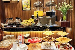 A buffet with various food items and beverages, including fruits, pastries, and milk. - RosaMay Thu Khoa Huan (Ho Chi Minh City)