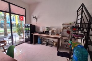 A kitchen with a dining table, chairs, a microwave, and a coffee maker. - ADRi (Phu Quoc Island)