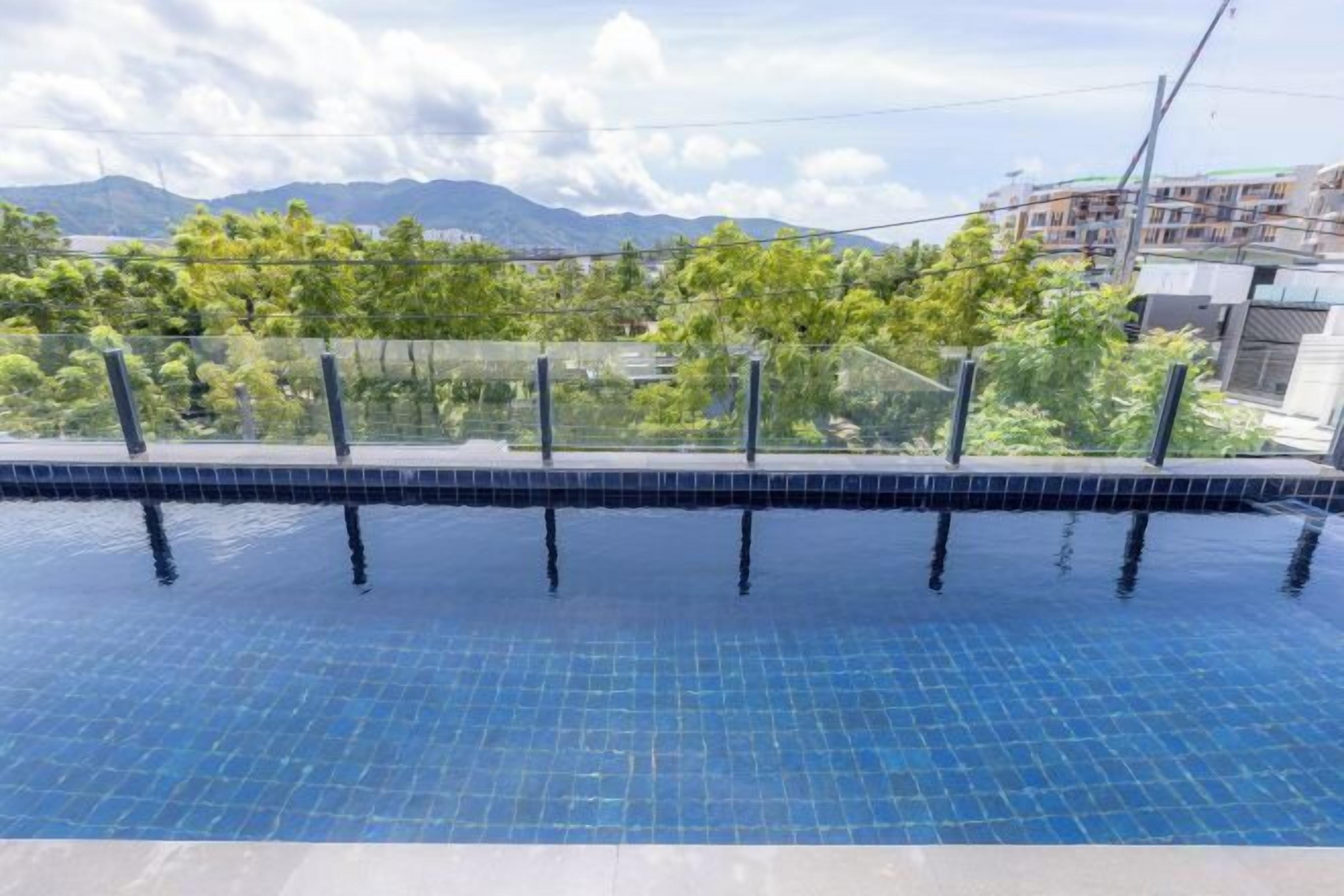 Una piscina con una vista despejada del paisaje circundante, incluyendo árboles y edificios a la distancia.