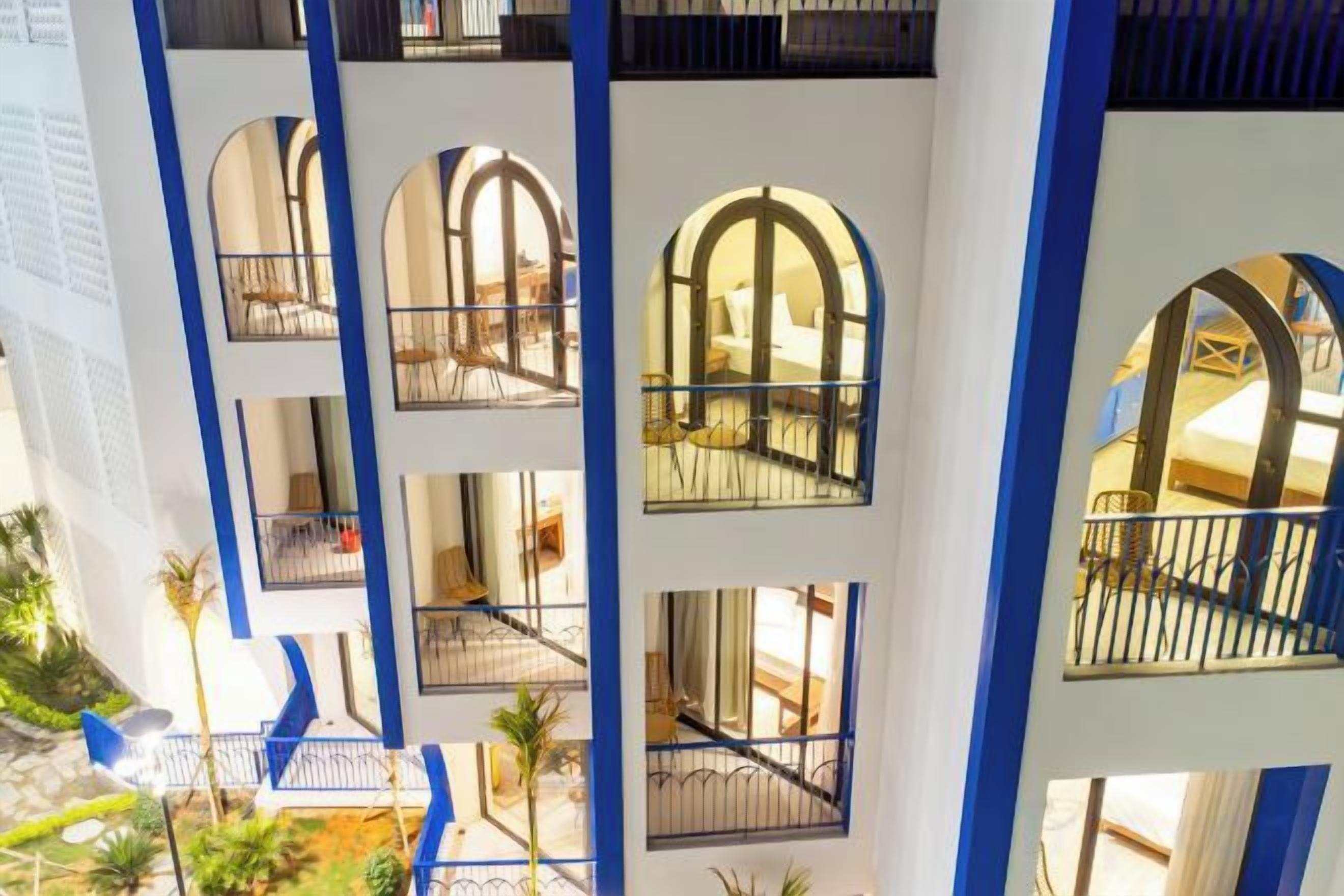 A multi-level hotel atrium with balconies and arched windows.