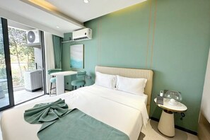 A modern hotel room with a bed, a small table, a chair, and a view of the outdoors. - Ark hotel Sihanoukville (Prey Nob)