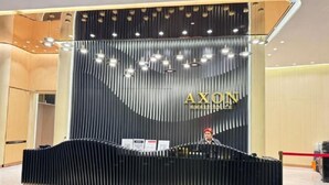 A reception desk with a modern design, featuring a black and gold color scheme and the name "AXON" prominently displayed. - Axon Residence Kuala Lumpur KLCC Pavillion BB (Kuala Lumpur)