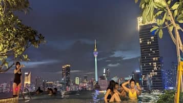 An outdoor swimming area with a city skyline in the background.