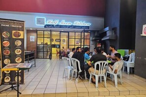 An outdoor seating area of a restaurant with a menu board on the left. - Jom La Homestay@ Putrajaya, Kajang (Bandar Baru Bangi)