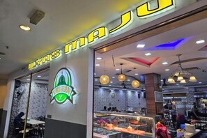 A restaurant with a neon sign, interior lighting, and a visible counter area. - Jom La Homestay@ Putrajaya, Kajang (Bandar Baru Bangi)