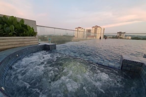 Piscina no terraço com vista para edifícios altos.