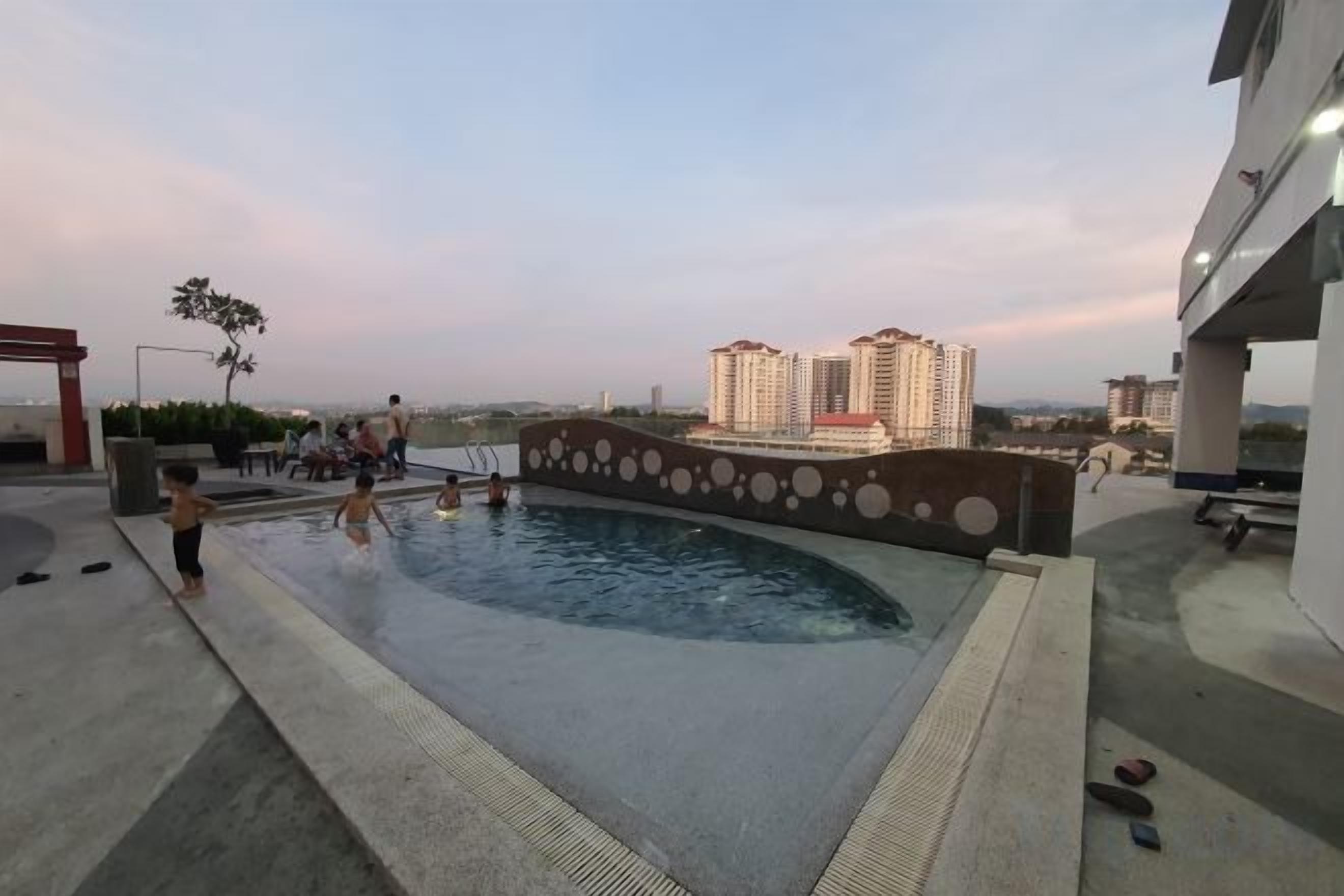 A rooftop swimming pool with a view of high-rise buildings.