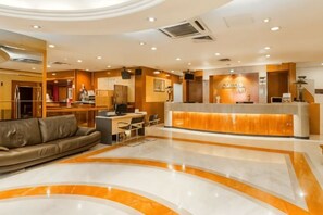 A hotel lobby with a reception desk, seating area, and a curved marble floor. - Kingston Hotel 6 @ Changkat Bukit Bintang (Kuala Lumpur)